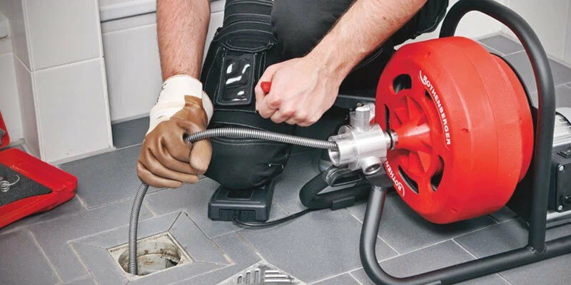 Plumber using a drain-cleaning machine in Tampa