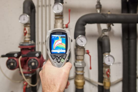 Plumber using a thermal imaging camera to inspect pipes in Tampa