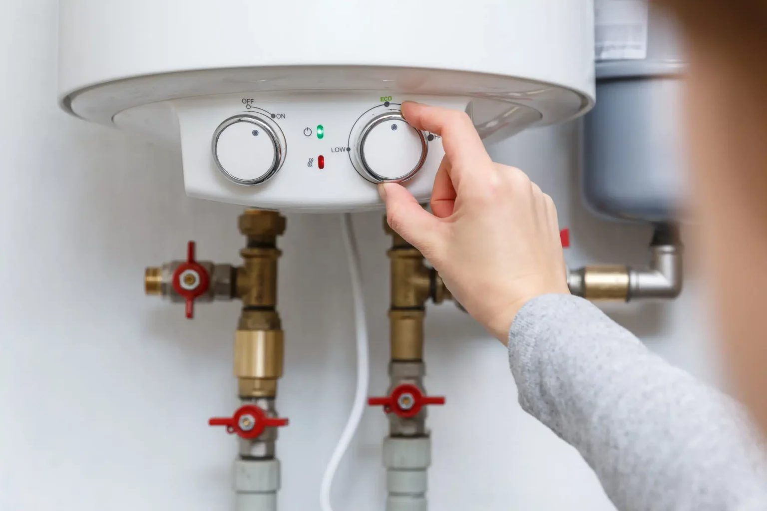 Homeowner adjusting the temperature controls on a water heater in Tampa